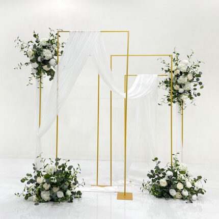 White rose wedding backdrop with greenery, gold rectangular metal frames and flowing white drapes